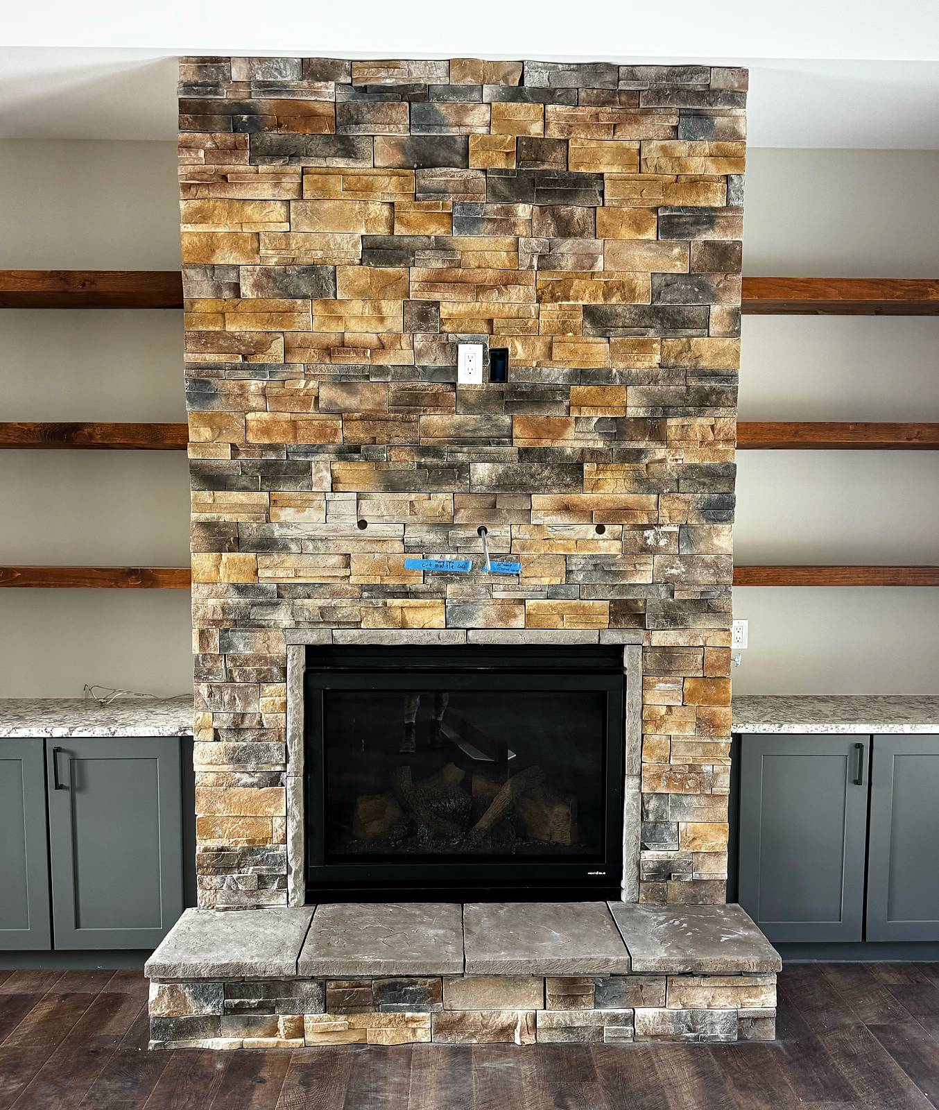 Floor-to-ceiling stacked stone fireplace with raised stone hearth